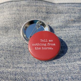 Ansteckbutton Tell me nothing from the horse auf Jeans mit Rückseite